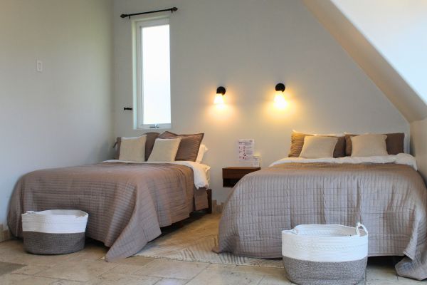 Shared bedroom with two neatly made beds and neutral furnishings